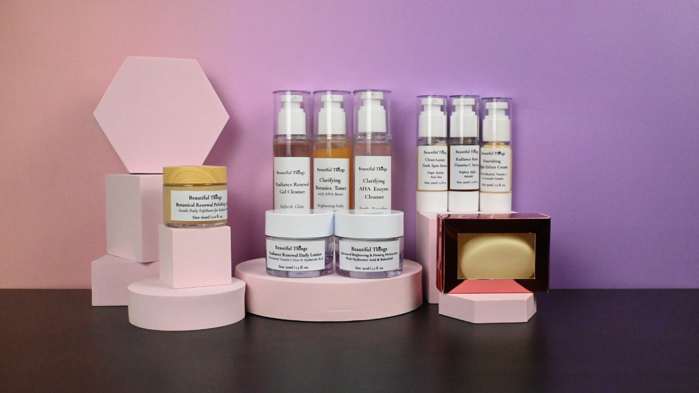 Beautiful Things skincare bottles and jars arranged on pastel pink pedestals against a pink and lilac background.
